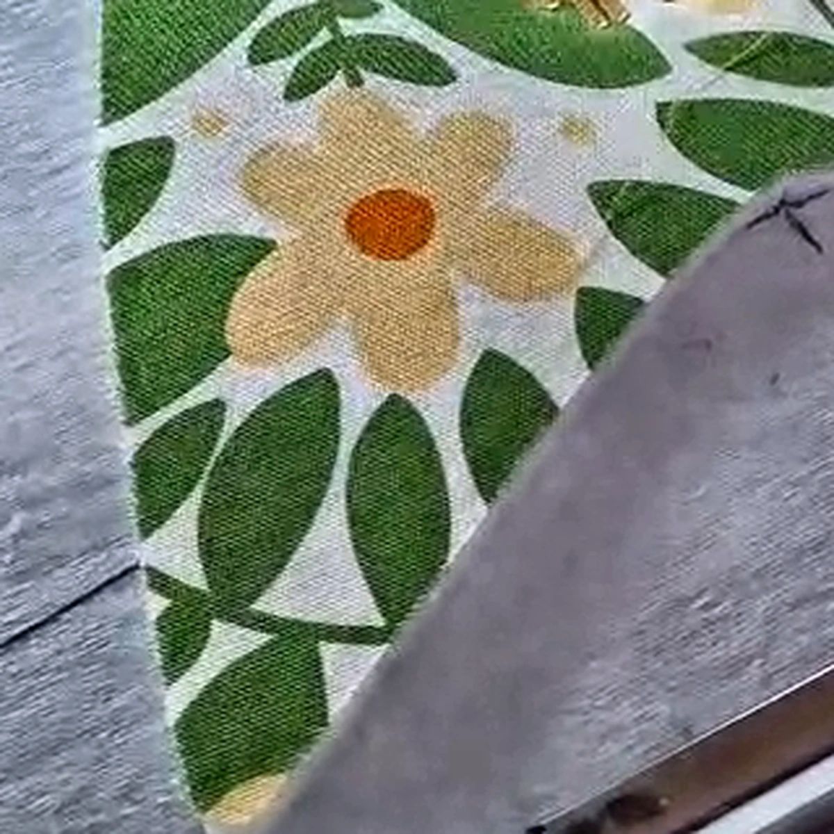 Kain motif bunga dengan tepi bordir